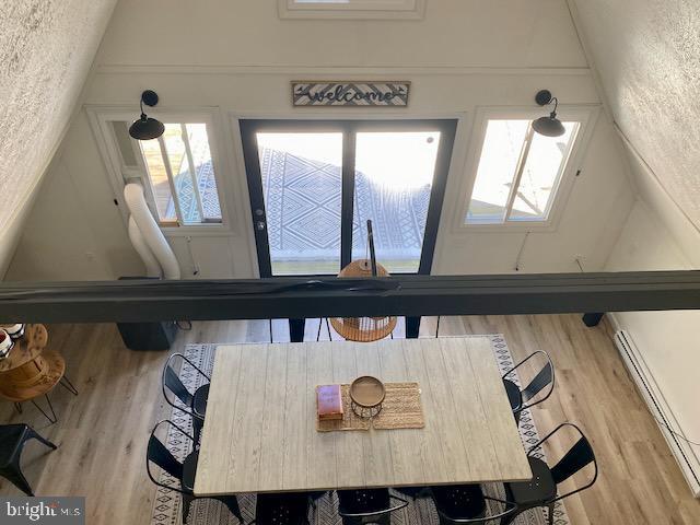 dining room with a baseboard heating unit and wood finished floors