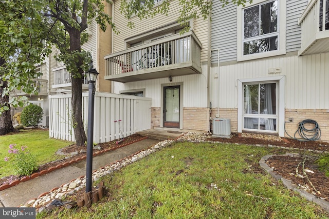 7233 Jillspring Ct Unit 18C, Springfield, VA 22152 - view of exterior entry with a balcony, brick siding, and a lawn