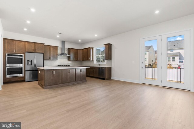 112 Heyford Dr, Stephenson, VA 22656 - kitchen with stainless steel appliances, wall chimney exhaust hood, light countertops, tasteful backsplash, and light wood-style flooring