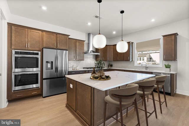 112 Heyford Dr, Stephenson, VA 22656 - kitchen featuring appliances with stainless steel finishes, wall chimney range hood, a kitchen island, backsplash, and recessed lighting