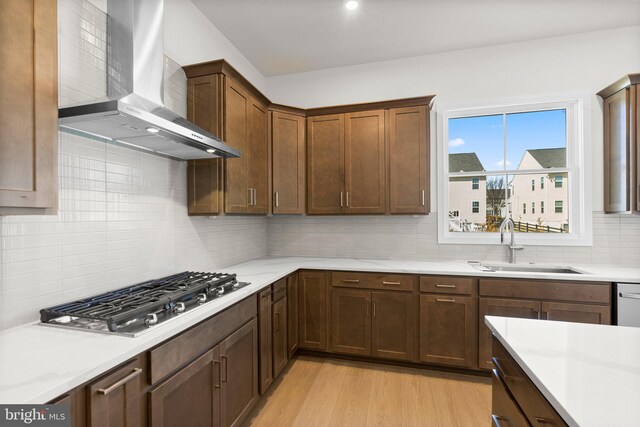 112 Heyford Dr, Stephenson, VA 22656 - kitchen featuring wall chimney range hood, stainless steel gas stovetop, a sink, light countertops, and backsplash