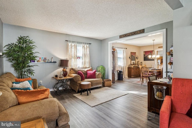 140 Grandview Ave, Hamilton, NJ 08620 - living room featuring a chandelier, healthy amount of natural light, wood finished floors, a textured ceiling, and baseboards