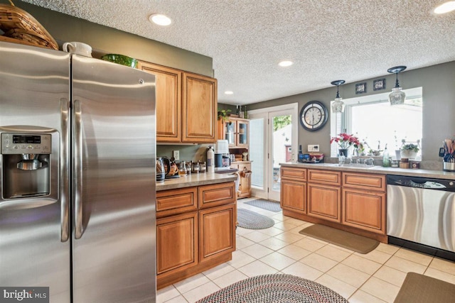 140 Grandview Ave, Hamilton, NJ 08620 - kitchen with stainless steel appliances, brown cabinetry, pendant lighting, light tile patterned floors, and a textured ceiling