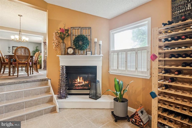 140 Grandview Ave, Hamilton, NJ 08620 - wine cellar featuring tile patterned floors, a chandelier, a textured ceiling, and a glass covered fireplace