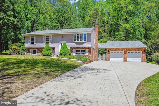 1176 Goldfinch Ln, Millersville, MD 21108 - raised ranch with a chimney, concrete driveway, an attached garage, a front lawn, and brick siding