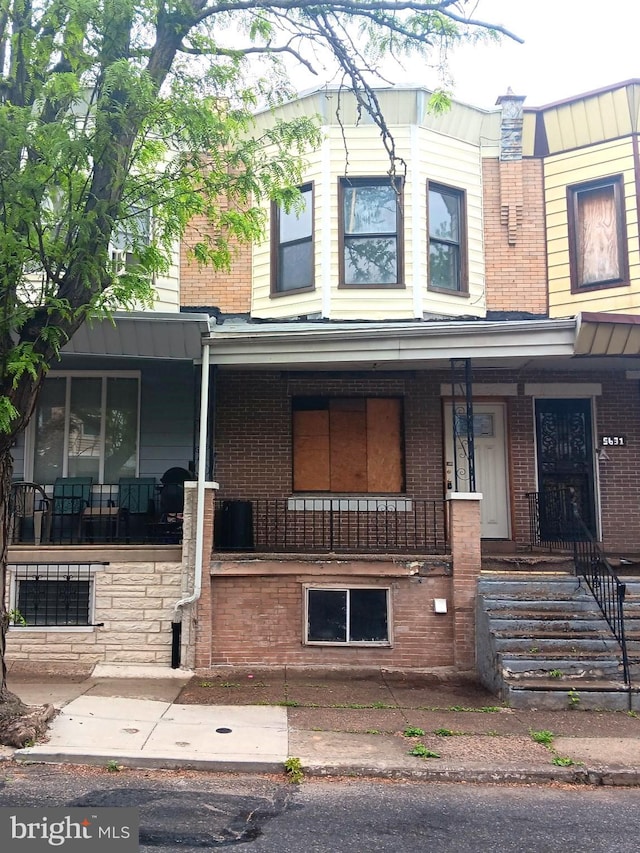 multi unit property with covered porch and brick siding