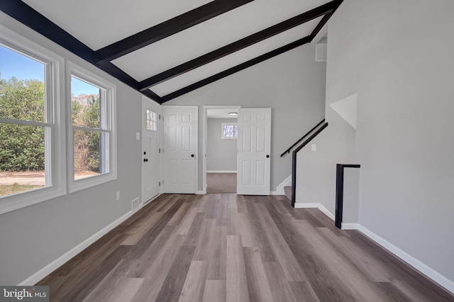 entryway featuring beam ceiling, wood finished floors, stairs, high vaulted ceiling, and baseboards