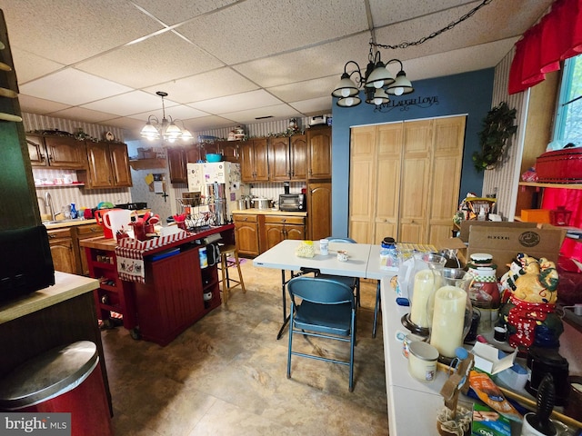 15 Weaver Ln, Brandywine, WV 26802 - kitchen with a chandelier, a paneled ceiling, light countertops, a kitchen island, and brown cabinetry