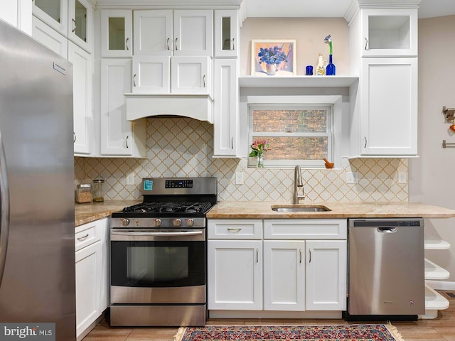 2332 E Baltimore St E, Baltimore, MD 21224 - kitchen featuring appliances with stainless steel finishes, a sink, white cabinetry, and decorative backsplash