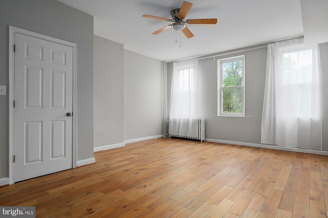 2332 E Baltimore St E, Baltimore, MD 21224 - spare room with radiator heating unit, a ceiling fan, light wood-style flooring, and baseboards
