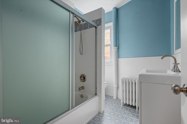 2332 E Baltimore St E, Baltimore, MD 21224 - full bathroom with radiator heating unit, toilet, vanity, and bath / shower combo with glass door