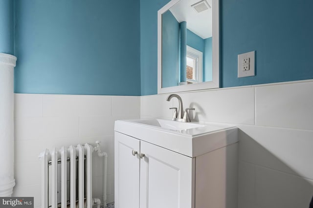 2332 E Baltimore St E, Baltimore, MD 21224 - bathroom featuring radiator, tile walls, vanity, and a wainscoted wall
