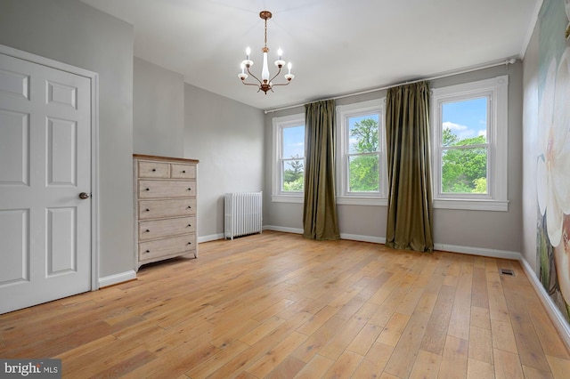 2332 E Baltimore St E, Baltimore, MD 21224 - spare room featuring radiator heating unit, a chandelier, healthy amount of natural light, and baseboards