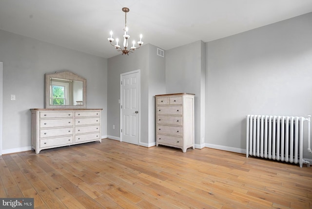 2332 E Baltimore St E, Baltimore, MD 21224 - unfurnished bedroom with radiator heating unit, a chandelier, light wood-style flooring, and baseboards
