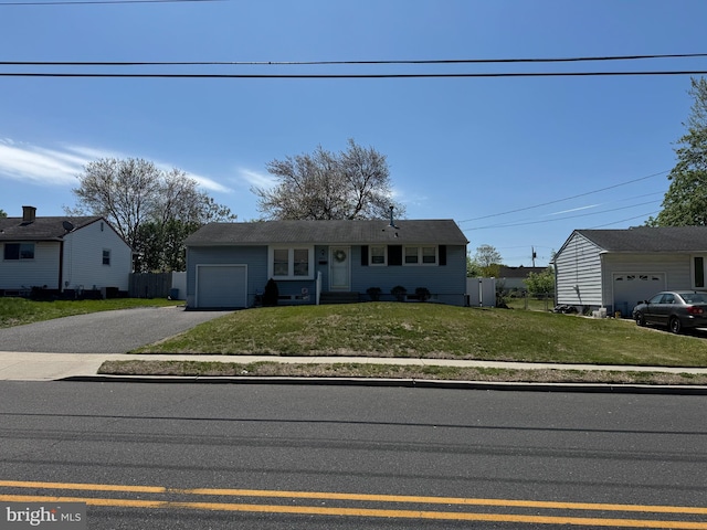 ranch-style house featuring asphalt driveway and an attached garage