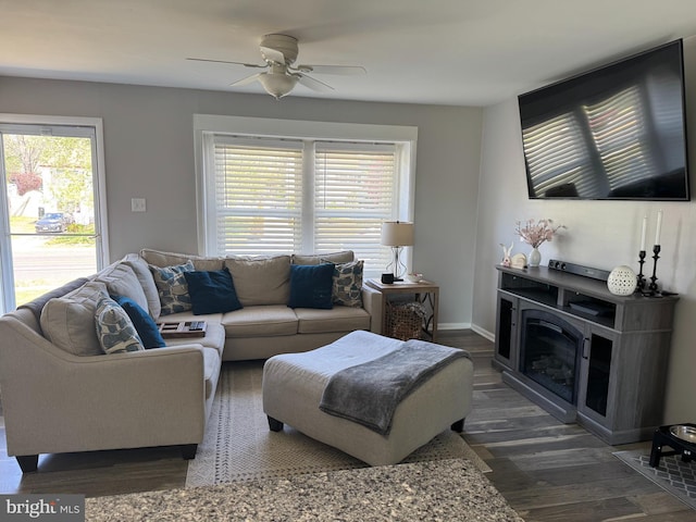 living room with wood finished floors, a ceiling fan, and baseboards