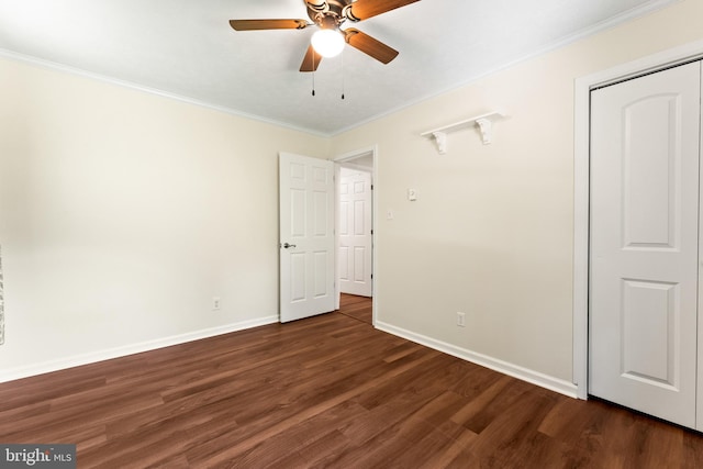unfurnished bedroom featuring crown molding, wood finished floors, baseboards, ceiling fan, and a closet
