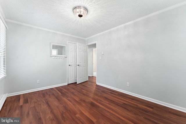 unfurnished room featuring a chandelier, wood finished floors, baseboards, and ornamental molding