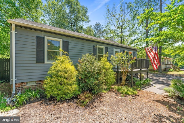 view of side of home with a wooden deck and crawl space