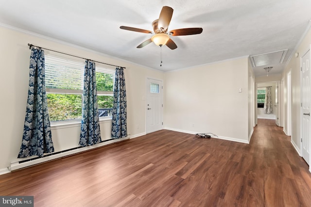 empty room featuring attic access, a ceiling fan, a baseboard radiator, wood finished floors, and crown molding