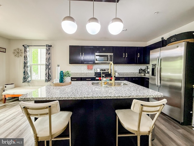 30 Sugarberry Dr, Elkton, MD 21921 - kitchen featuring appliances with stainless steel finishes, a sink, light wood-style floors, and a kitchen bar