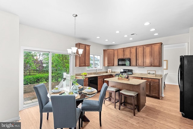 924 Towering Oak Ct, Purcellville, VA 20132 - kitchen featuring black appliances, a sink, a center island, light wood-style floors, and hanging light fixtures