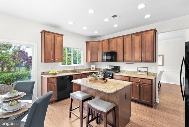 924 Towering Oak Ct, Purcellville, VA 20132 - kitchen featuring black appliances, a sink, a kitchen bar, light wood-style flooring, and recessed lighting