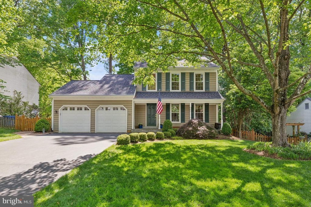 traditional home featuring driveway, an attached garage, and a porch