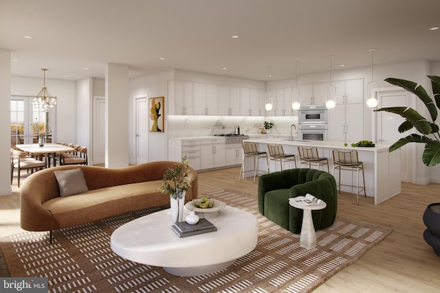 living area featuring light wood finished floors, a chandelier, and recessed lighting