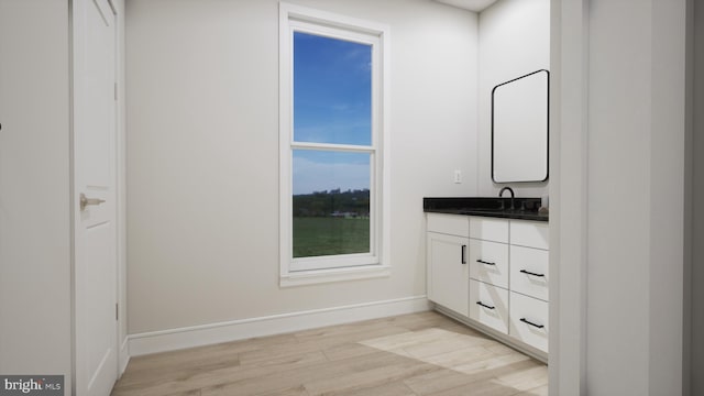 bathroom featuring vanity, wood finished floors, and baseboards
