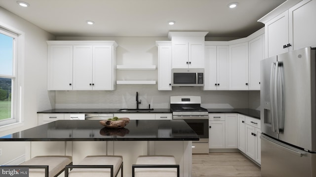 kitchen featuring stainless steel appliances, a sink, open shelves, dark countertops, and recessed lighting