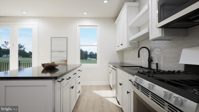 kitchen featuring gas stove, dark countertops, a sink, backsplash, and recessed lighting