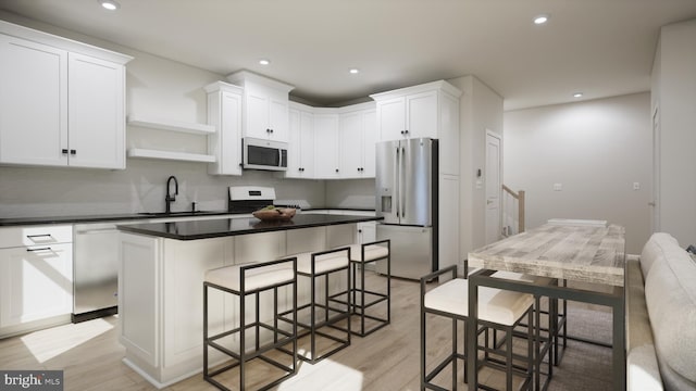kitchen featuring stainless steel appliances, a sink, open shelves, a breakfast bar area, and light wood-style flooring