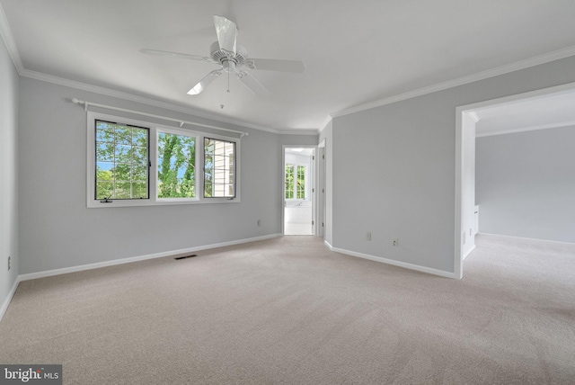 unfurnished room with a ceiling fan, crown molding, carpet floors, and baseboards