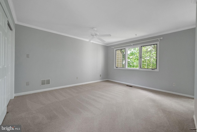 carpeted spare room featuring ornamental molding, ceiling fan, and baseboards