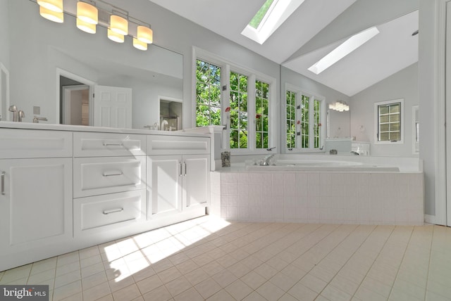 bathroom featuring a skylight, tile patterned flooring, a bath, vaulted ceiling, and double vanity