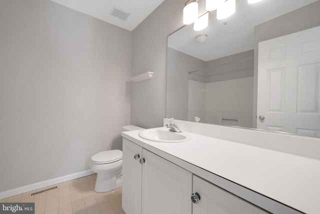 bathroom featuring toilet, baseboards, vanity, and a shower