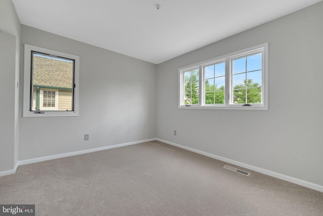 unfurnished room with baseboards and carpet