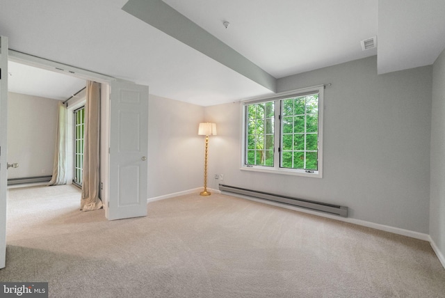 carpeted spare room featuring a baseboard heating unit, baseboards, and a baseboard radiator