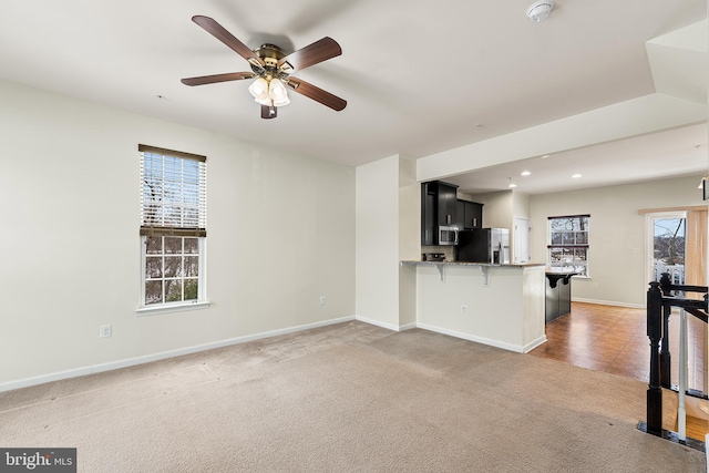 unfurnished living room featuring baseboards, ceiling fan, light colored carpet, and recessed lighting