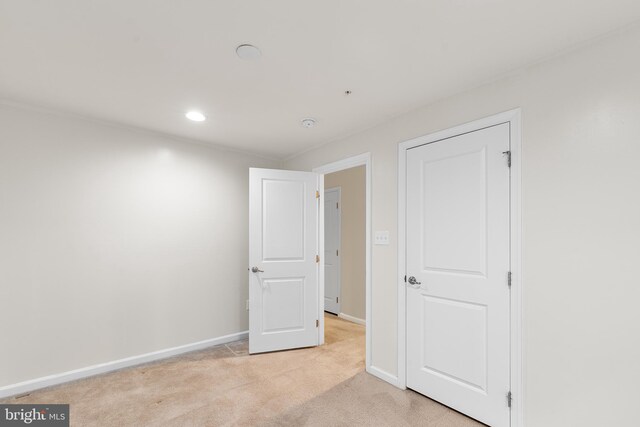 unfurnished bedroom with light colored carpet, recessed lighting, and baseboards