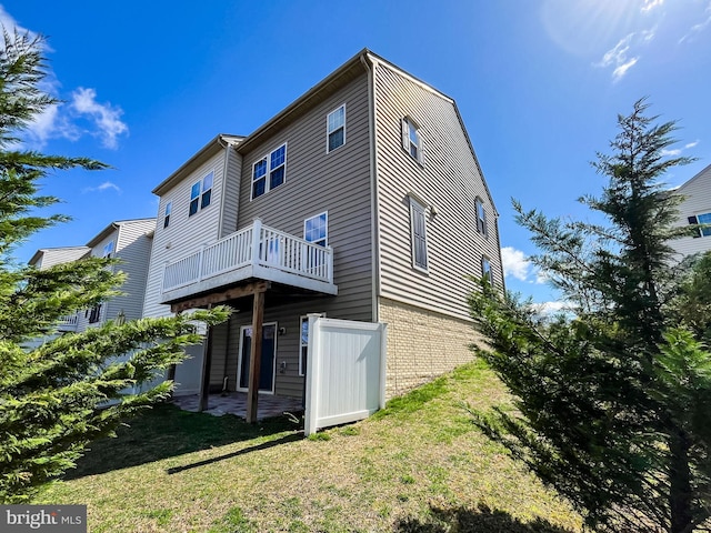 back of property featuring a lawn and brick siding