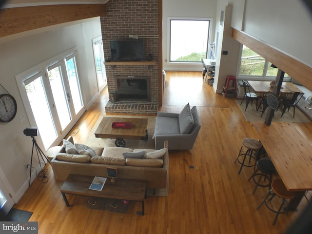 living area with wood finished floors and a brick fireplace