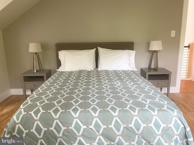 bedroom featuring baseboards and wood finished floors