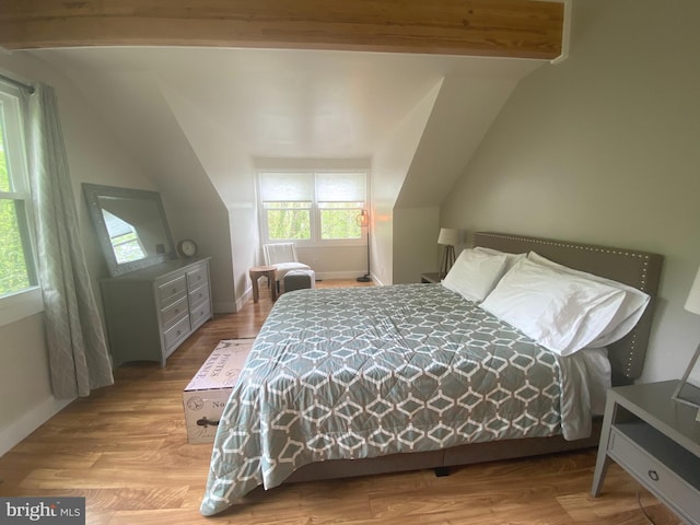 bedroom featuring vaulted ceiling, baseboards, and wood finished floors