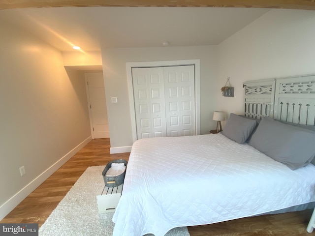 bedroom featuring a closet, baseboards, and wood finished floors