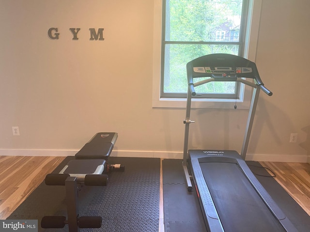 exercise area with wood finished floors and baseboards