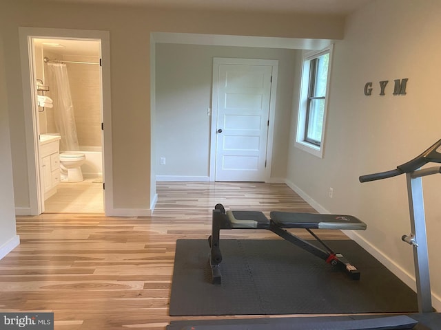 exercise area featuring baseboards and light wood-type flooring