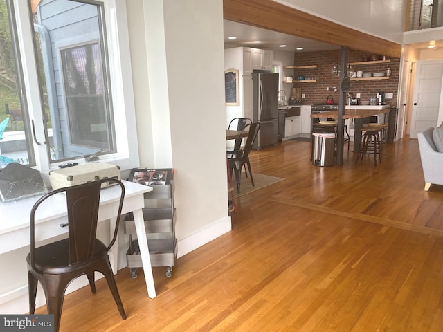 dining area featuring light wood-style flooring and baseboards