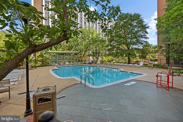 community pool with fence and a patio